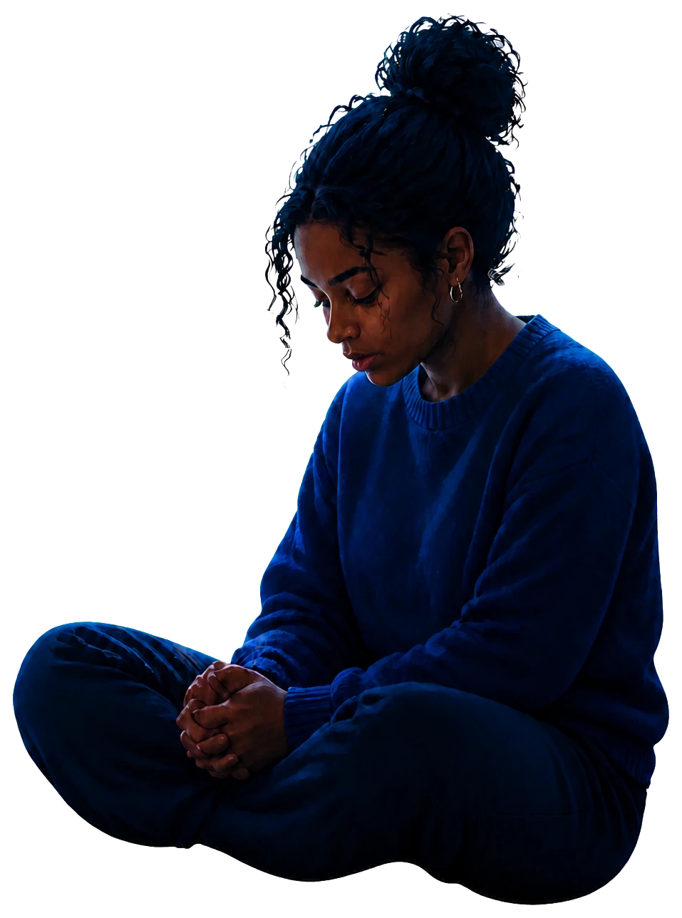 A woman sitting quietly with her hands clasped in reflection